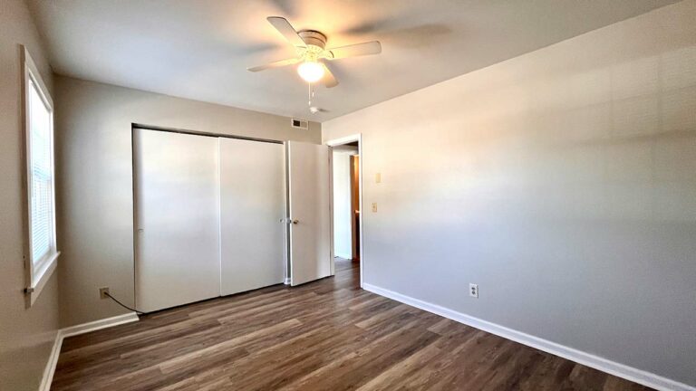 Pine Bridge Apartments bedroom with ceiling fan and reach-in closet with sliding doors