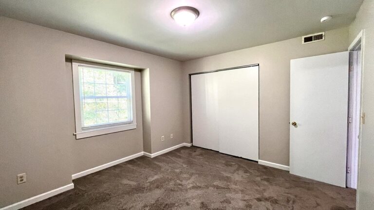 Pine Bridge Apartments bedroom with carpet and blinds on window