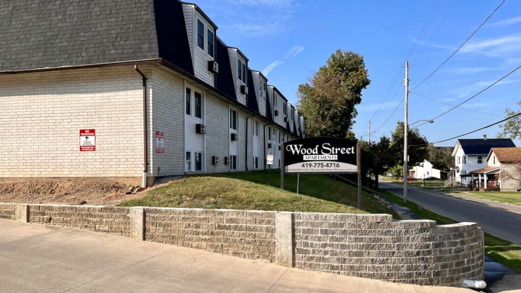 Wood Street Apartments property sign in front of brick apartment building